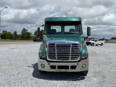 Front view of a green 2015 Freightliner Cascadia 113 tow truck with chrome grille and black mirrors.