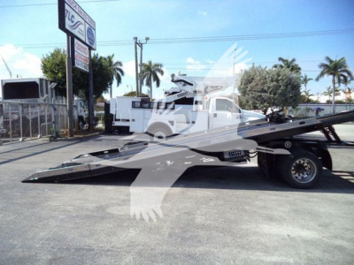 Ford F650 rollback truck side view showing low-profile flatbed with hydraulic tilt mechanism and wheel on rear; 'T06405' stock label not visible on image.