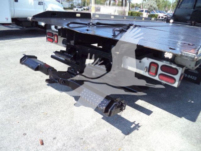 Truck rollback bed rear with hitch and auxiliary components visible.