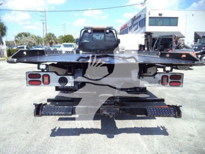 Ford F650 rollback truck rear view showing platform, taillights, and bumper steps.