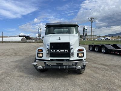 Front view of a white 2025 Mack MD7 heavy truck in a lot showing Mack grille with large bumper and headlights.