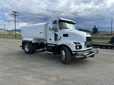 Mack MD7 truck in white with water tanker body profile showing front grille and side tank; clean, in-service appearance; no visible text aside from small 'MACK' badge on grille.