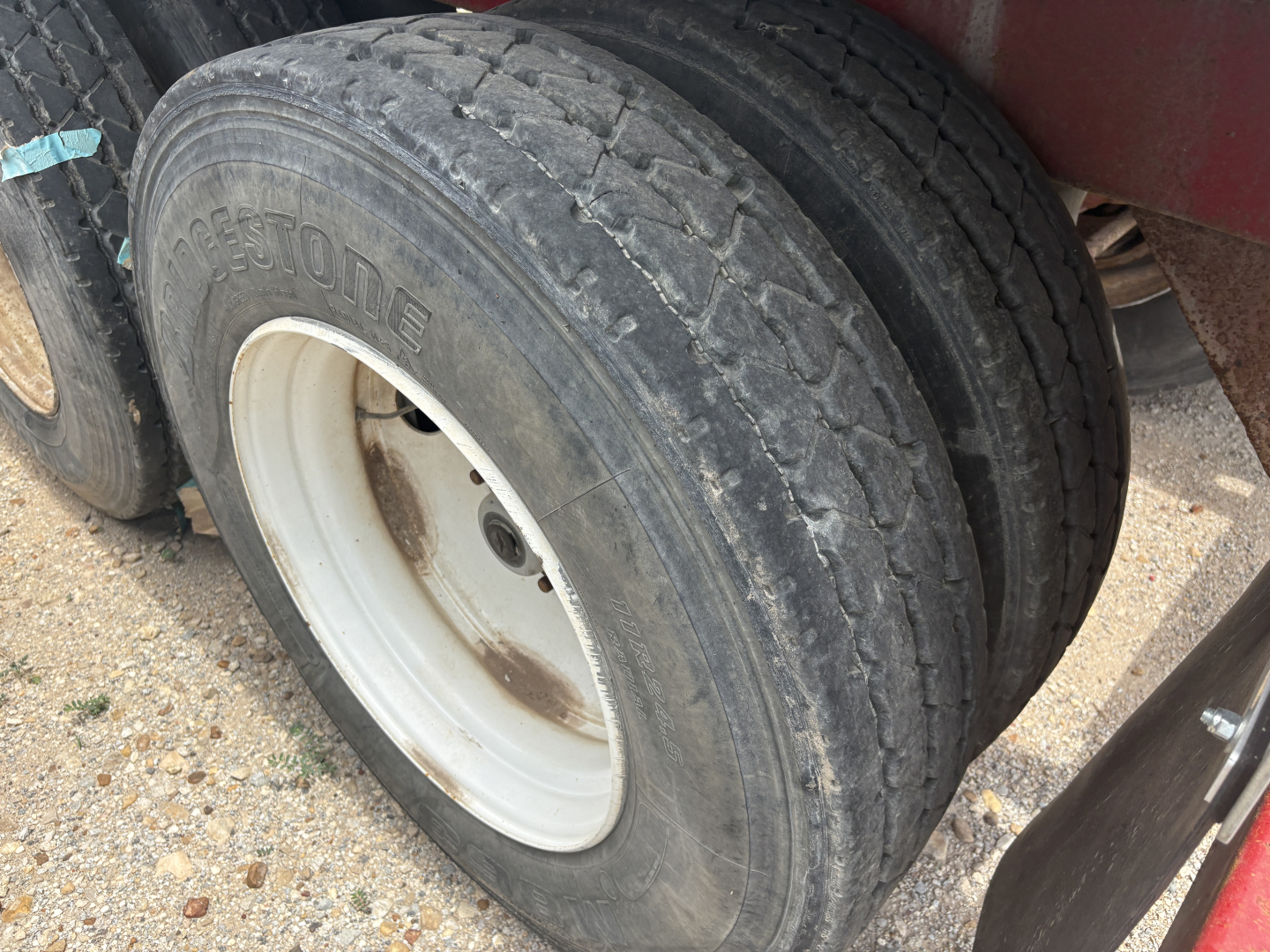 Dual rear tires on a trailer showing tread and white wheel rims.