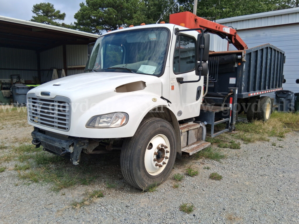 Grapple truck in-service showing white cab with orange boom and rear carrier bed.
