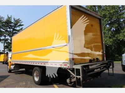 Box truck with yellow trailer showing rear view, white wings graphic on side, rear bumper, and taillights.