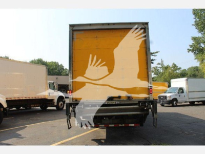 Rear view of a box truck with a yellow roll-up door; silhouettes of birds overlaying the door.