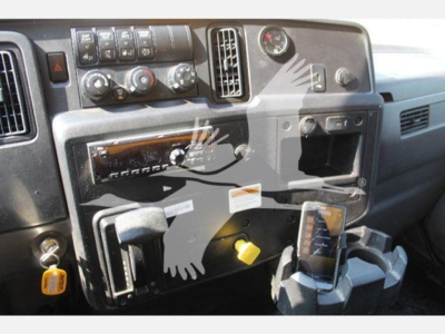 Dashboard and center console of a 2020 International Mv truck interior showing switches, gauges, and a mounted device; visible text includes control labels and a yellow key tag.