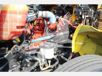 Truck engine bay showing coolant reservoir, hoses, and various engine components in a used 2020 International MV box truck.