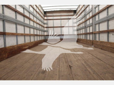 Truck interior cargo area showing empty wooden floor and metal side walls with rails; watermark of a flying bird silhouette overlay.