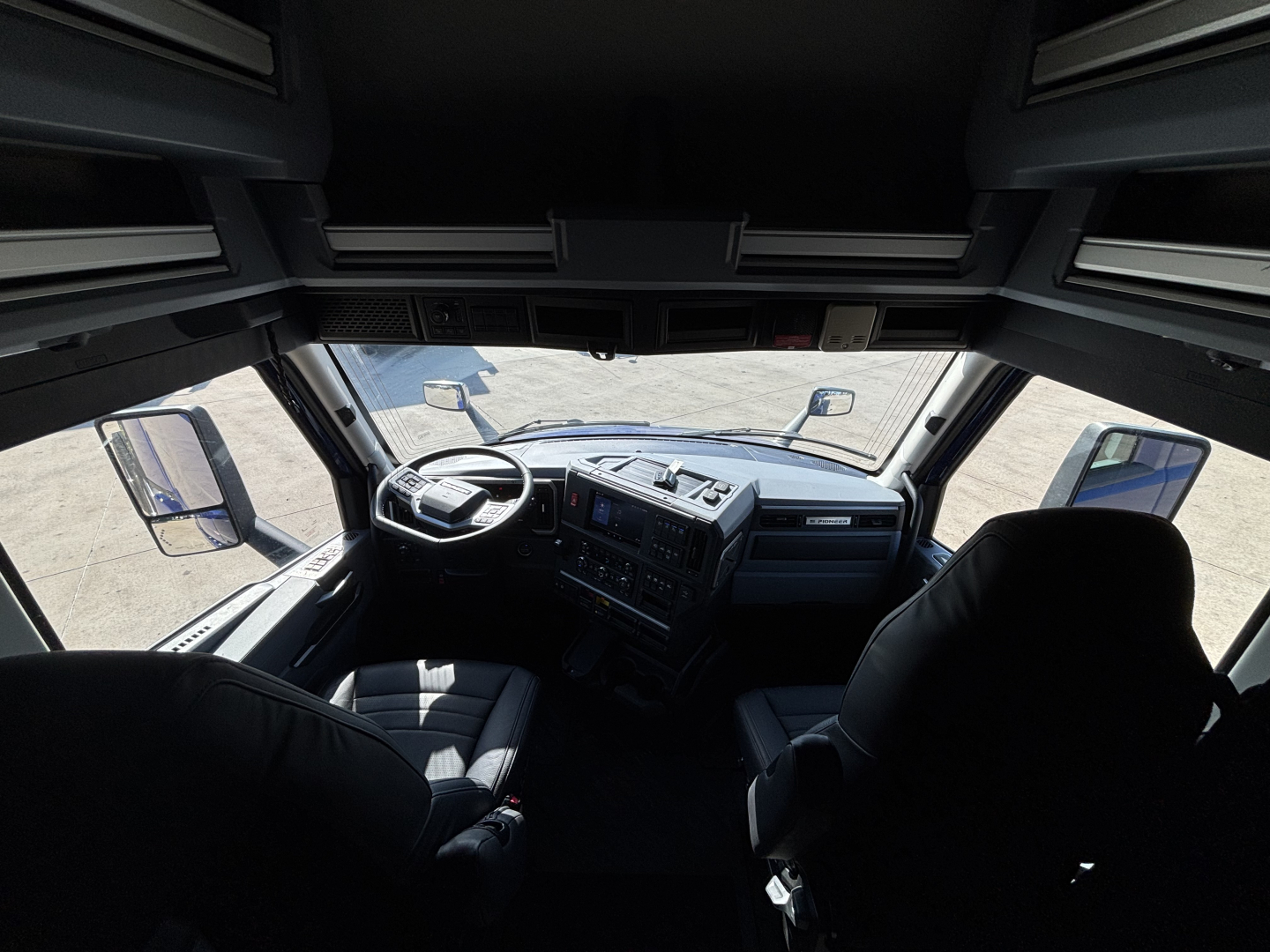 Cab interior of a 2027 Mack PR64T76H sleeper tractor showing dashboard, steering wheel, and seats.