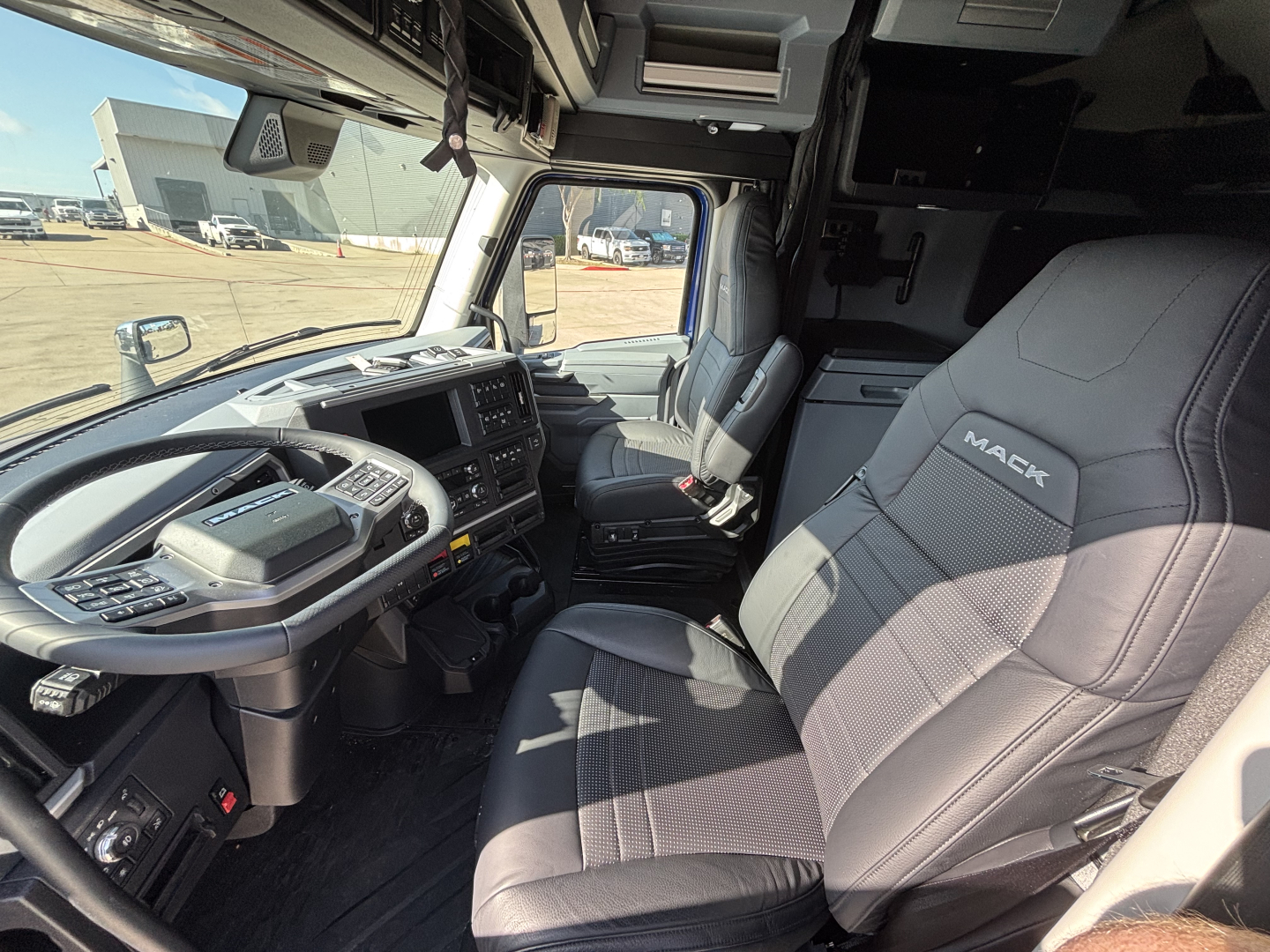 Mack PR64T76H tractor cab interior showing driver seat and dashboard with controls.