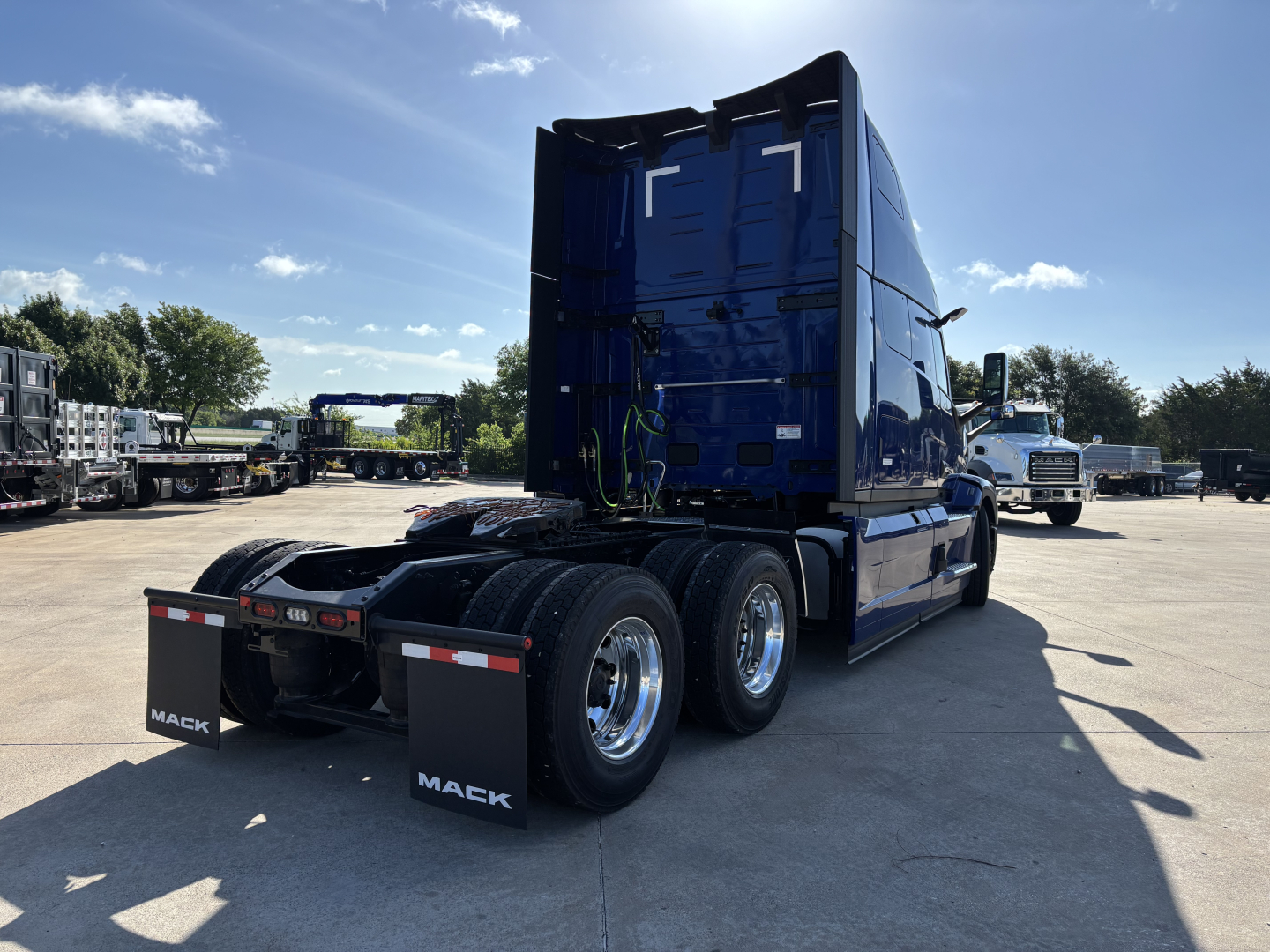 Blue 2027 Mack PR64T76H day cab sleeper tractor rear three-quarter view showing dual rear axles and fifth wheel