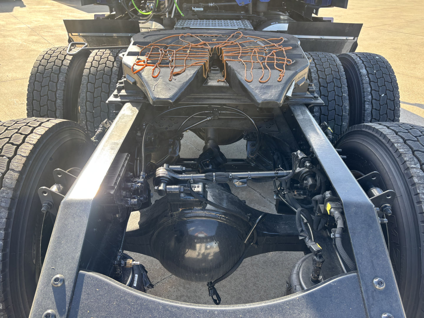 Tractor rear undercarriage of a Mack PR64T76H showing twin rear axles and fifth-wheel area with driveline and suspension components