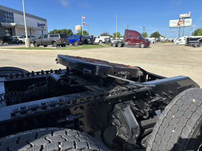 Mack PR64T76H tractor shows chassis and fifth wheel coupling with visible chains and heavy-duty tires.