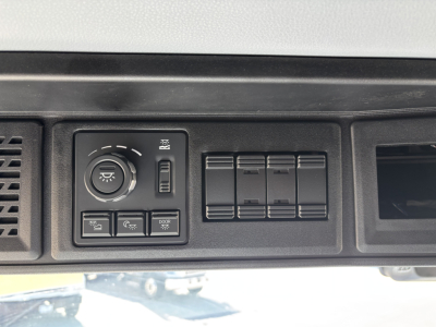 Dashboard controls of a Mack PR64T76H truck showing headlight/dome switch, panel with five vertical rocker switches, and blank panel; no legible VIN or numbers visible.