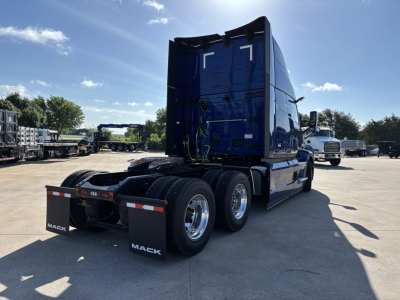Blue 2027 Mack PR64T76H day cab sleeper tractor rear three-quarter view showing dual rear axles and fifth wheel