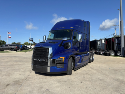 Blue Mack PR64T76H tractor cab in a dealership lot, front-left view, with chrome grille and high sleeper, no visible text on cab.