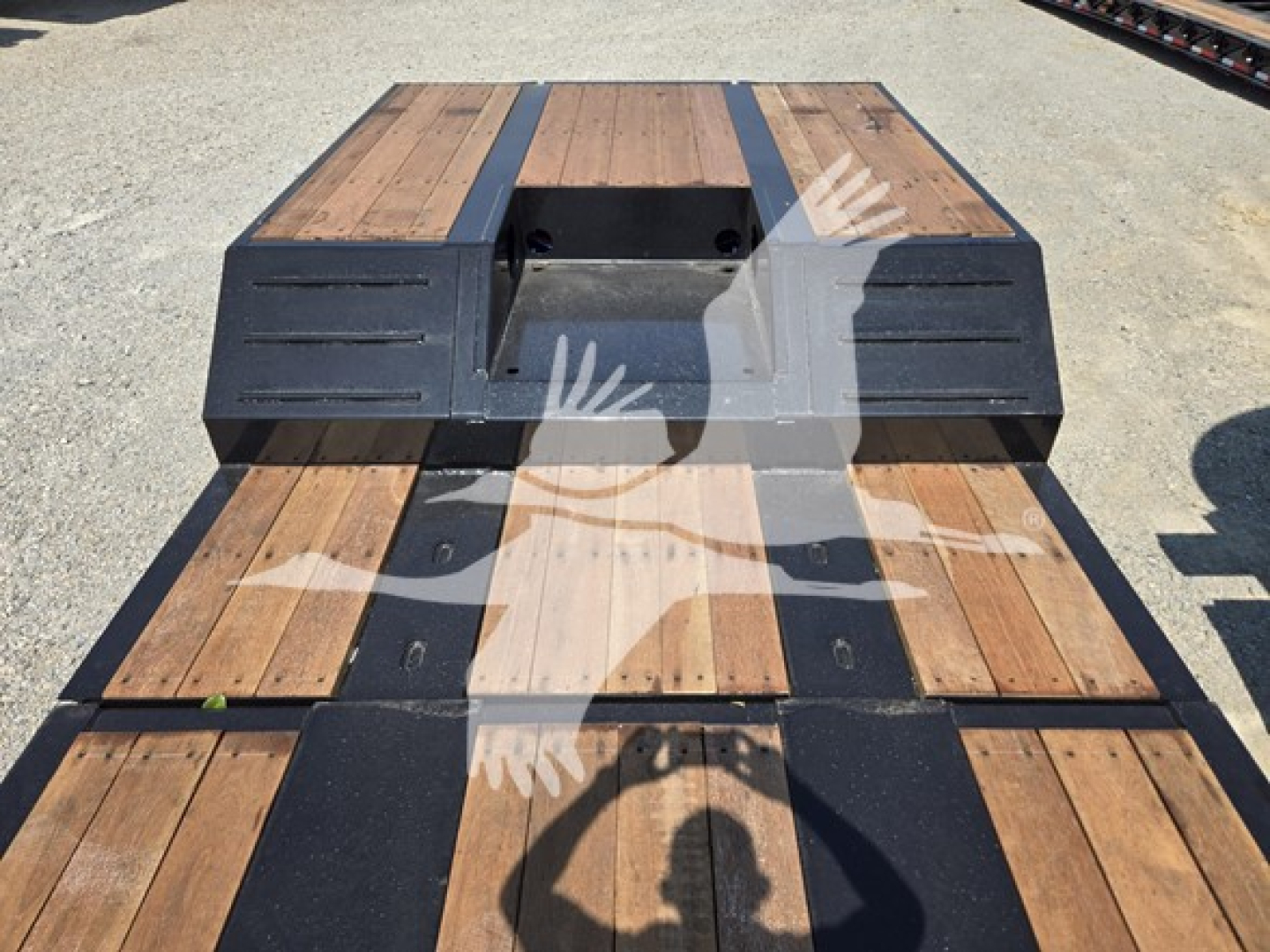  Fontaine Renegade X20 trailer deck with wooden planks and black steel frame, rear view showing flatbed sections with cutouts and storage pockets.
