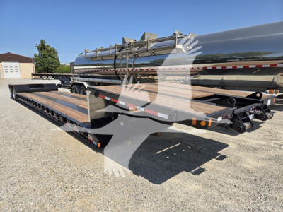 Double drop expandable trailer showing long flatbed with wooden deck and silver cylindrical tank mounted on top, connected to gooseneck hitch area.