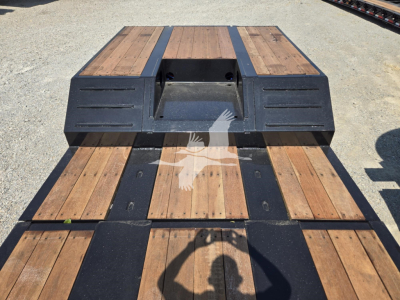 Fontaine Renegade X20 trailer deck with wooden planks and metal framing. View shows rear/ankle area and storage pocket in center; no visible branding text.