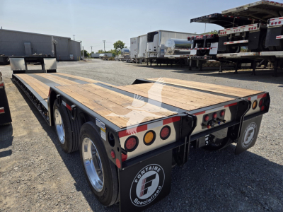Fontaine Renegade X20 trailer showing wooden deck and rear bumper lights with dual axles and Fontaine logo on mudflap.