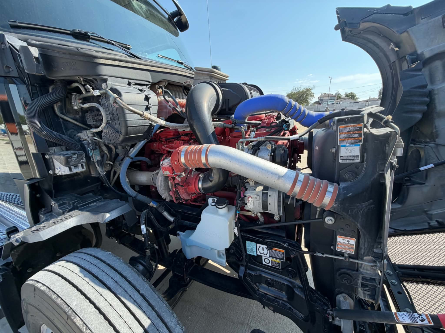 Kenworth T680 engine bay showing turbocharger, hoses, and radiator area.