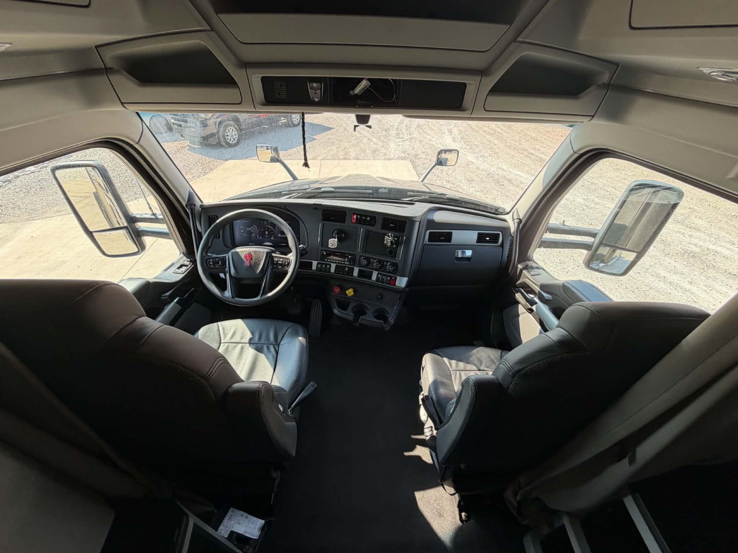 Kenworth T680 truck interior dashboard and steering wheel view from cab with two front seats.