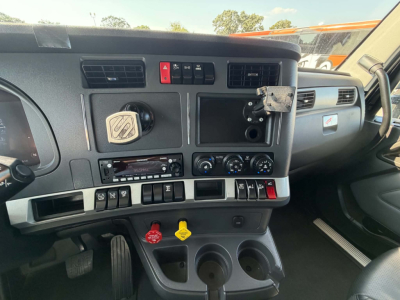 Kenworth T680 cab interior dash with steering wheel, center console controls, air vents, and dashboard switches visible.