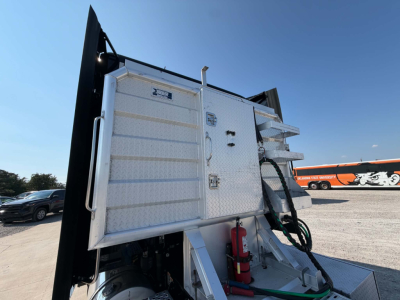 Kenworth T680 dump body side view showing diamond plate aluminum toolbox and step access with fire extinguisher mounted near chassis.