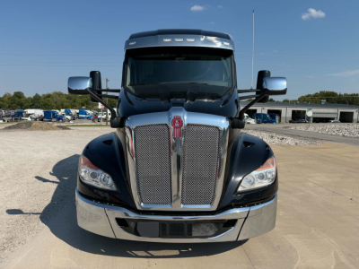 Kenworth T680 front view with large chrome grille and badge, clear windshield, side mirrors visible.