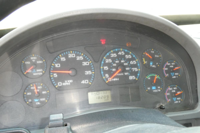 Dashboard view of a 2004 International 4300 instrument cluster showing speedometer, tachometer, fuel, and warning lights.