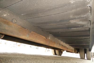 Underneath view of a 2004 International 4300 truck showing the underside frame and wheels.