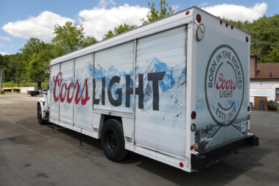 In-service white beverage truck trailer with Coors Light logo on side and back; mountains depicted; circular Coors logo on rear corner; no visible part numbers.