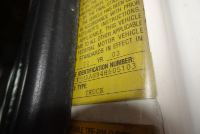Truck door jamb label showing identification numbers and vehicle type. Visible text includes 'IDENTIFICATION NUMBER: 1HTMMAAN94H605103' and 'TYPE: TRUCK' on a yellow sticker.