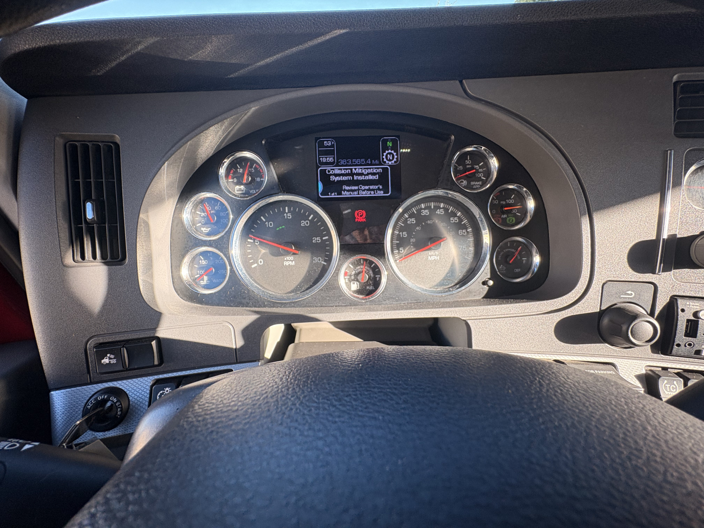 Kenworth T680 dashboard view showing instrument cluster with multiple gauges and a central digital display.