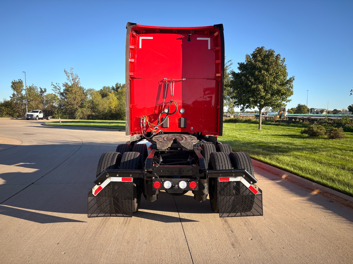 rear view of a red Kenworth truck tractor without a trailer, showing the cab and fifth wheel area.