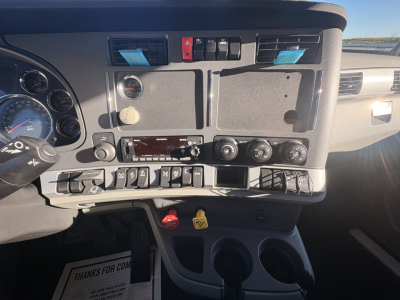 Kenworth T680 truck dash panel with controls, gauges, and cup holders visible.