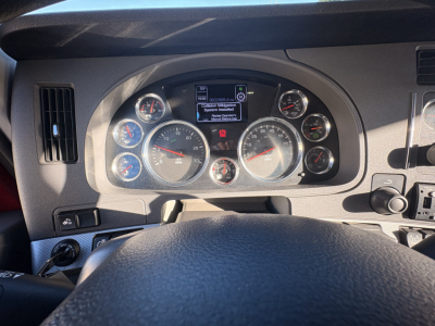 Kenworth T680 dashboard view showing instrument cluster with multiple gauges and a central digital display.