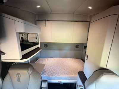 Kenworth T680 sleeper cab interior showing bunk bed area and storage cabinets.