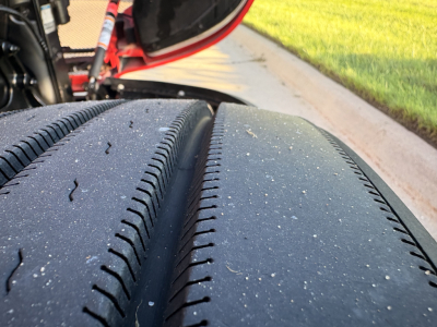Kenworth T680 wheel and tire close-up view in-service with visible tread and asphalt grit.