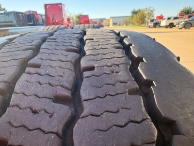Kenworth T680 truck tire tread close-up in a dealership lot.