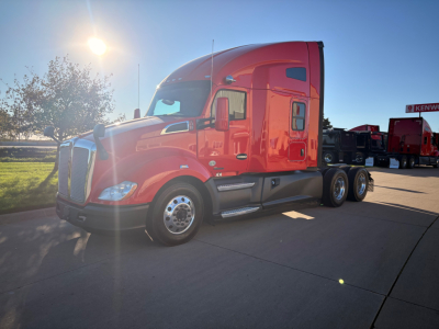 Kenworth T680 conventional sleeper truck in red, side view showing cab and dual rear axles.