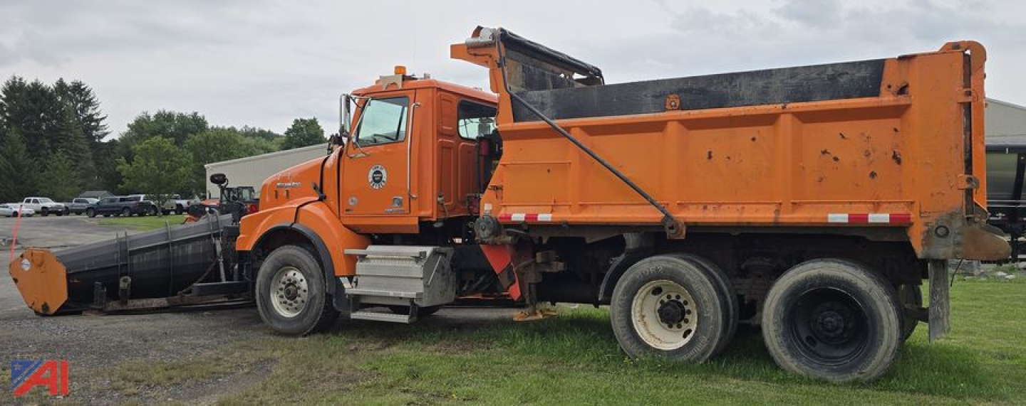 Orange 2012 Western Star 4900 SB dump truck with plow, side view showing dump bed and twin rear wheels.