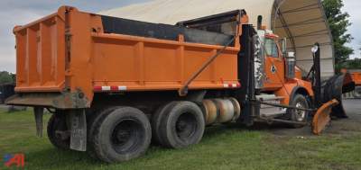 Dump truck 2012 Western Star 4900 SB with plow attachment showing orange cab and dump bed side view.