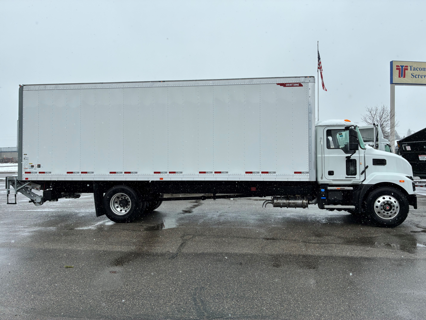 Truck side view of a new 2025 Mack MD6 box truck showing long rectangular cargo body and cab with white exterior.