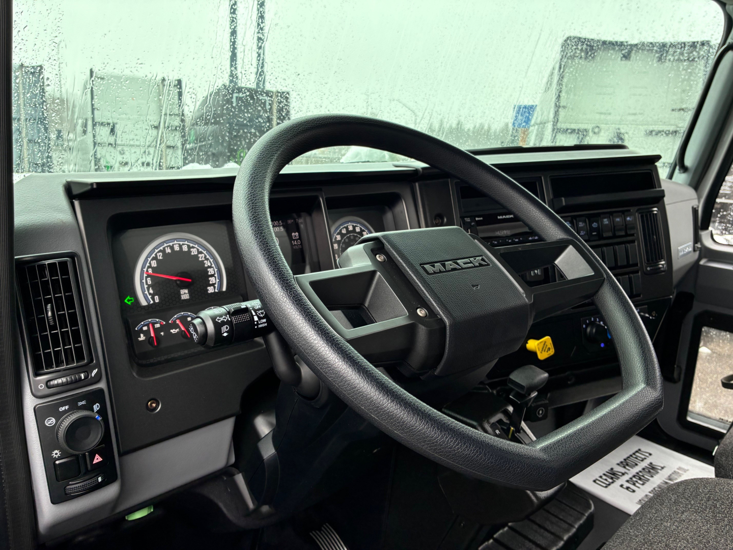 Mack MD6 truck cabin interior showing steering wheel and dashboard with gauges and controls.