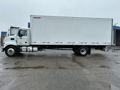 Truck side view showing a white 2025 Mack MD6 box truck with a large cargo box and dual rear wheels.