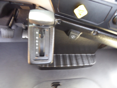 Mack MD6 interior with gear selector in view and accelerator pedal, showing shifter and dashboard area.