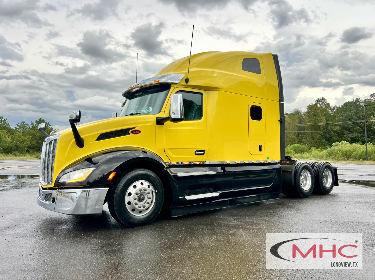 Peterbilt 579 tractor in yellow with sleeper cab, chrome bumper, black chassis, dual rear axles, stock photo with MHC logo.