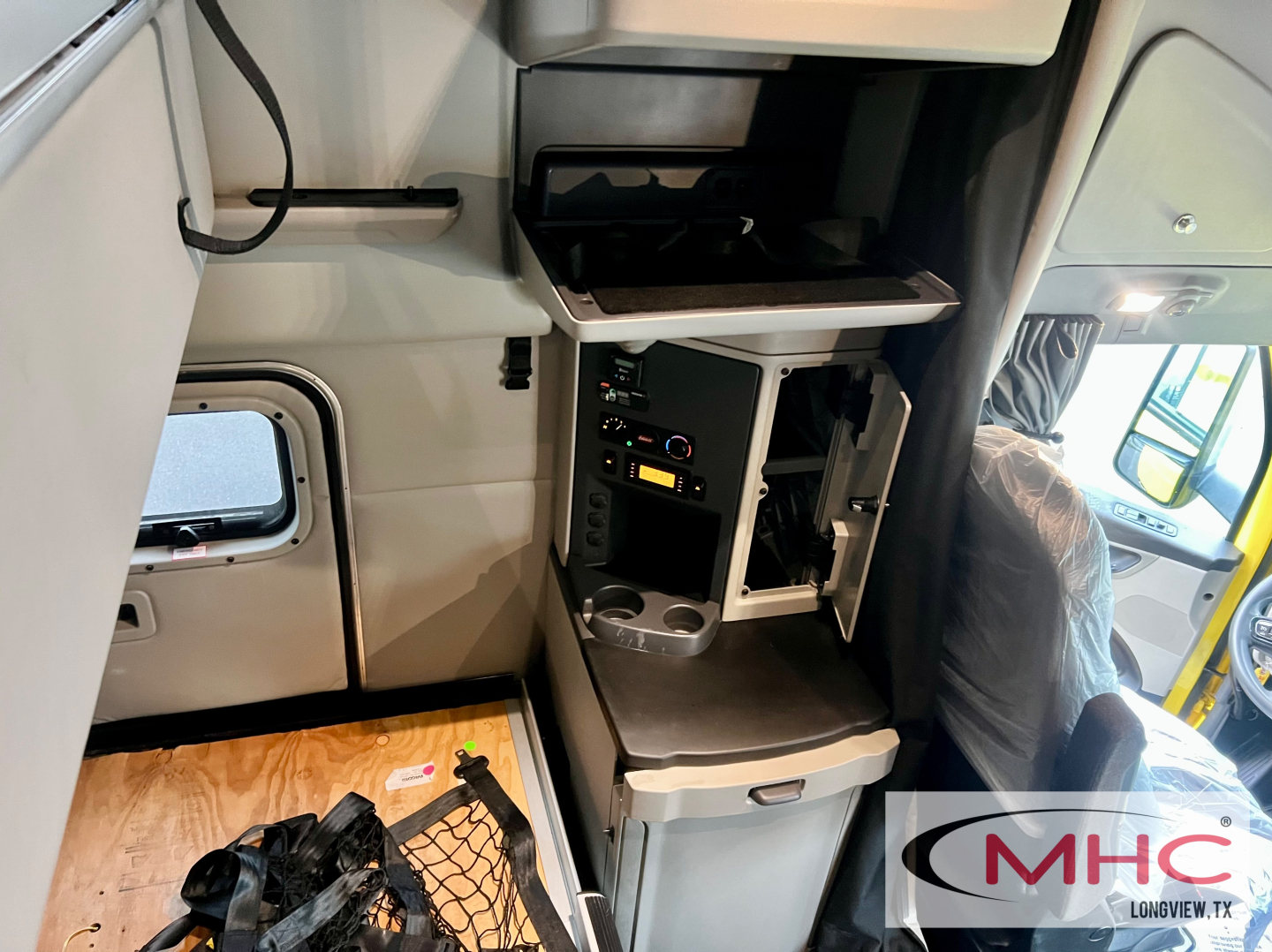 Peterbilt 579 cab interior showing driver area with cabinet, control panel, and storage drawer.